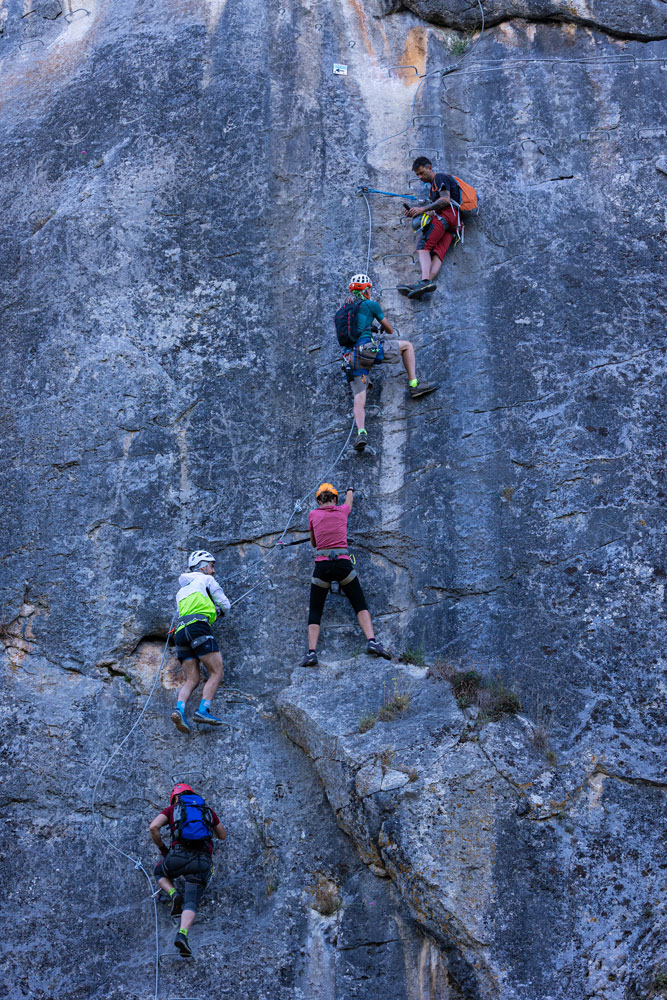 Excursionistas atravesando una sección vertical en la Vía Ferrata de Cistierna
